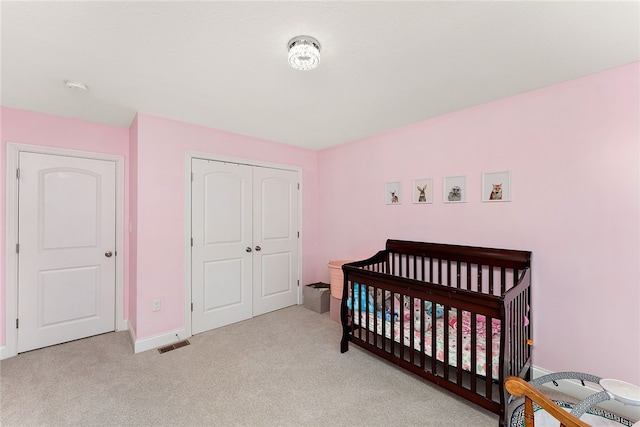 bedroom featuring light colored carpet and a closet