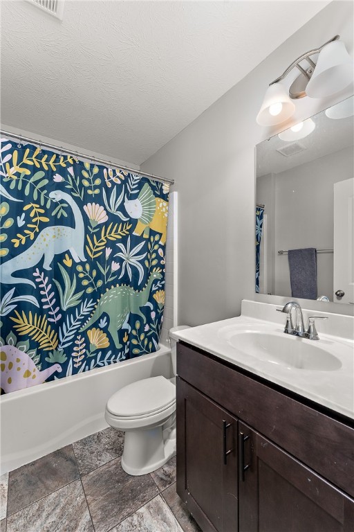 full bathroom featuring vanity, shower / tub combo, toilet, and a textured ceiling