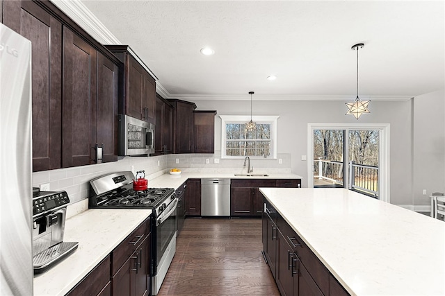 kitchen featuring sink, decorative light fixtures, a healthy amount of sunlight, and appliances with stainless steel finishes