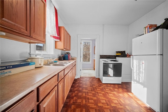 kitchen featuring sink, white appliances, and dark parquet floors