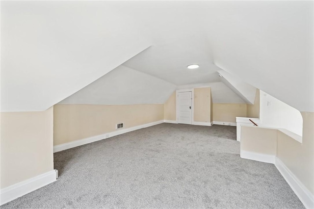 additional living space with vaulted ceiling and light carpet