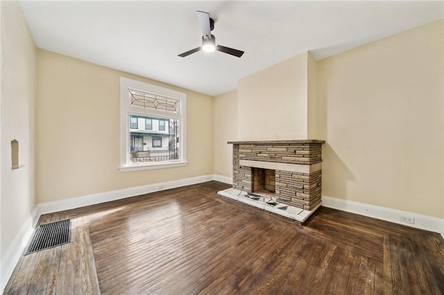 unfurnished living room with dark hardwood / wood-style floors, ceiling fan, and a fireplace