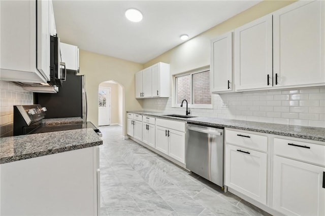 kitchen with white cabinetry, appliances with stainless steel finishes, sink, and light stone counters