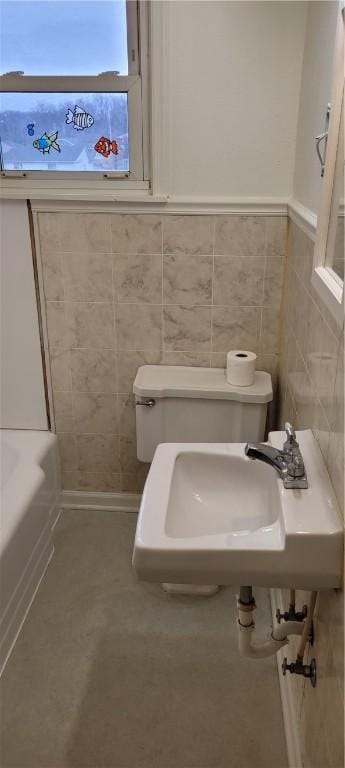 bathroom featuring tile walls, sink, and toilet