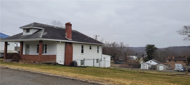 view of side of property with cooling unit, a yard, and covered porch