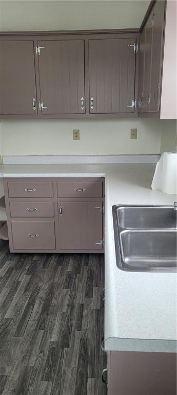 kitchen with dark brown cabinetry, sink, and dark hardwood / wood-style floors