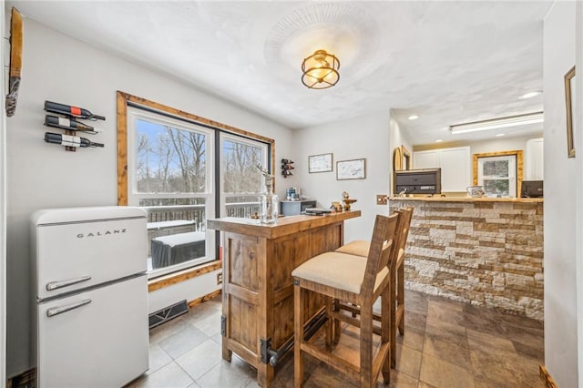 interior space with white cabinets and white refrigerator