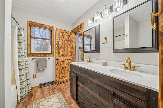 bathroom with shower / bath combo with shower curtain, wood-type flooring, and vanity