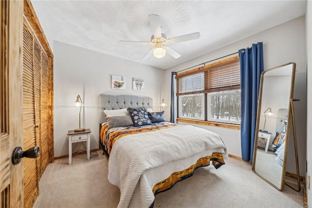 bedroom featuring light colored carpet, a closet, and ceiling fan