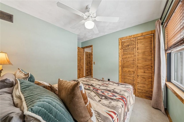 carpeted bedroom featuring ceiling fan and a closet