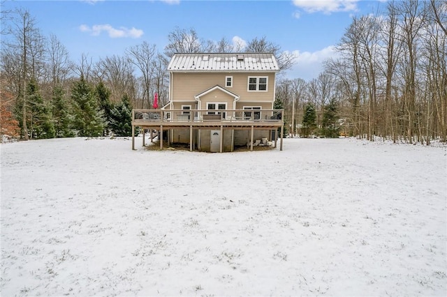 snow covered rear of property featuring a deck