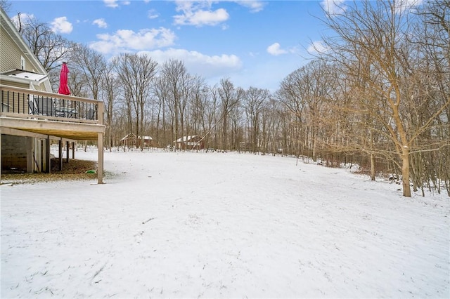 yard layered in snow with a deck