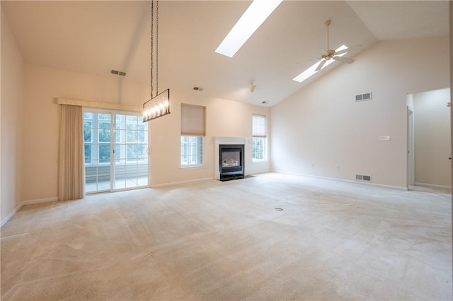 unfurnished living room featuring ceiling fan, light carpet, high vaulted ceiling, and a skylight