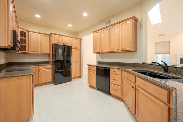 kitchen featuring dark stone countertops, sink, light brown cabinets, and black appliances