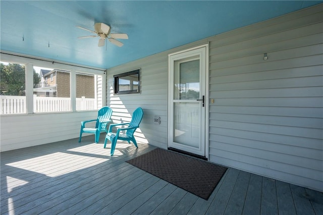 unfurnished sunroom featuring ceiling fan