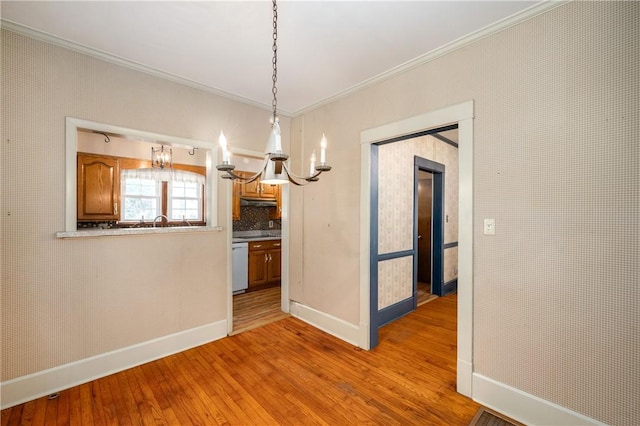 unfurnished dining area with ornamental molding, light hardwood / wood-style floors, and a notable chandelier