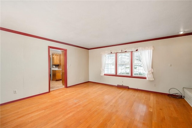 empty room featuring crown molding and light hardwood / wood-style floors