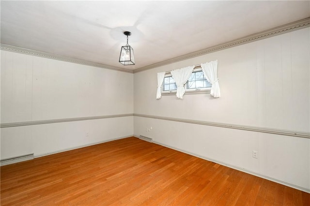 unfurnished room featuring ornamental molding, hardwood / wood-style floors, and baseboard heating