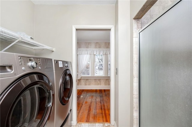 laundry area featuring washing machine and clothes dryer and light wood-type flooring