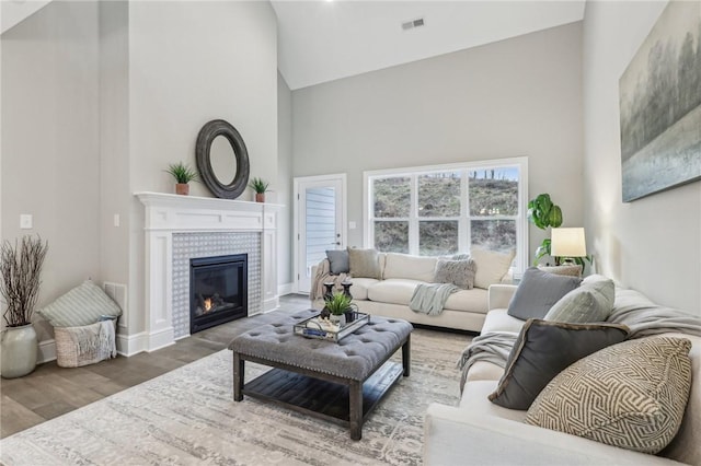 1045 Lakeside Dr, Mcdonald Wsh, PA 15057 - living room with hardwood / wood-style flooring, a tiled fireplace, and high vaulted ceiling