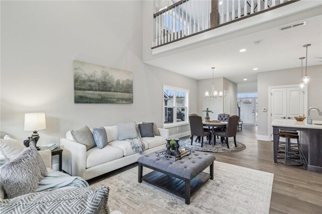 1045 Lakeside Dr, Mcdonald Wsh, PA 15057 - living room with an inviting chandelier, hardwood / wood-style flooring, and a towering ceiling