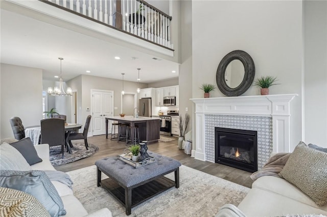 1045 Lakeside Dr, Mcdonald Wsh, PA 15057 - living room featuring a high ceiling, hardwood / wood-style floors, a notable chandelier, and a fireplace