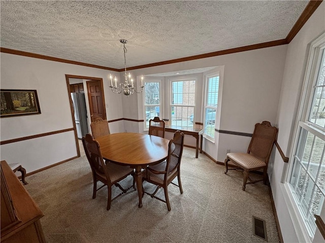 carpeted dining space featuring a notable chandelier, ornamental molding, and a textured ceiling