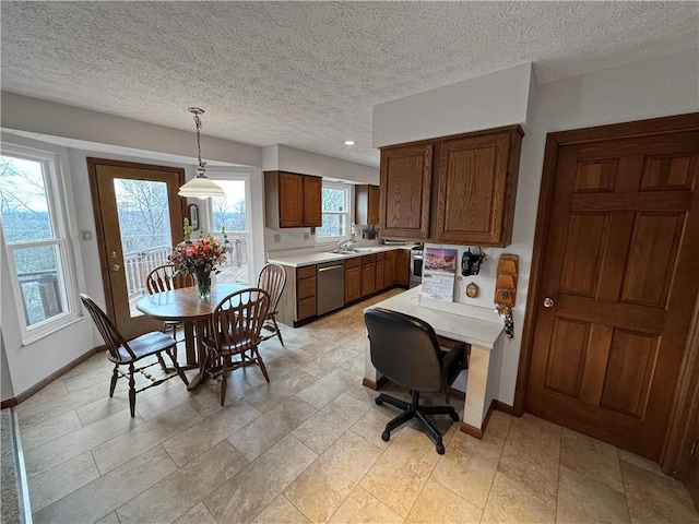 kitchen featuring hanging light fixtures, dishwasher, sink, and a textured ceiling