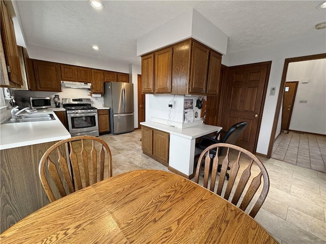 kitchen featuring appliances with stainless steel finishes, sink, and a textured ceiling