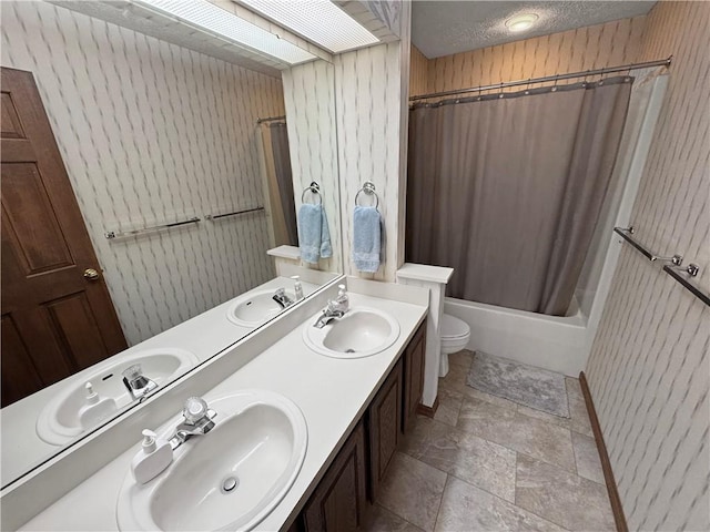 full bathroom with shower / tub combo with curtain, vanity, toilet, and a textured ceiling