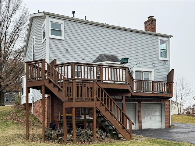 rear view of house featuring a garage and a deck