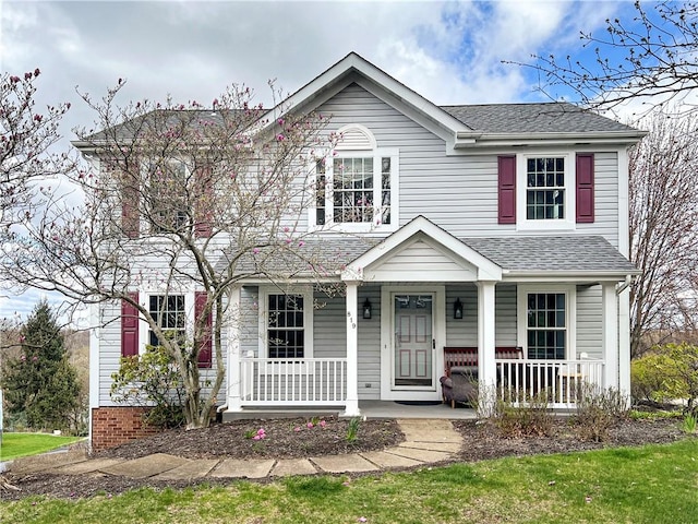 view of front of home featuring roof with shingles and a porch