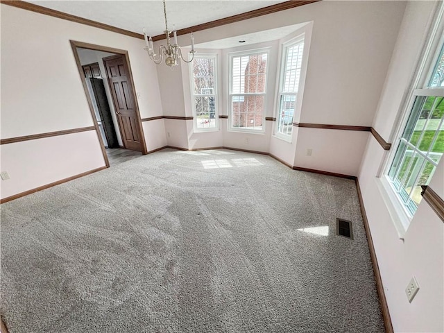 unfurnished dining area featuring baseboards, an inviting chandelier, carpet flooring, crown molding, and visible vents