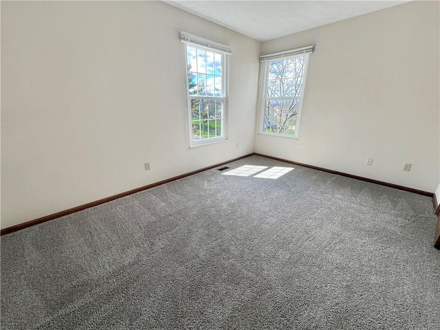 spare room with visible vents, baseboards, and carpet