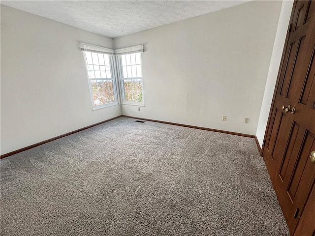 unfurnished bedroom with visible vents, baseboards, carpet, and a textured ceiling