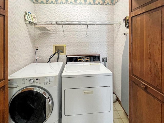 washroom with washing machine and clothes dryer, laundry area, and wallpapered walls