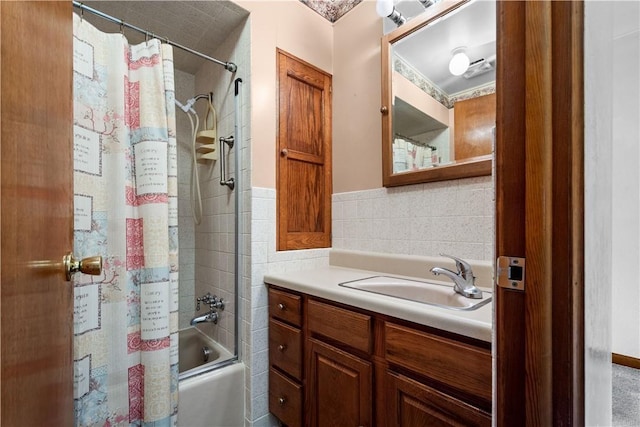 bathroom featuring vanity, tile walls, and shower / bath combo with shower curtain