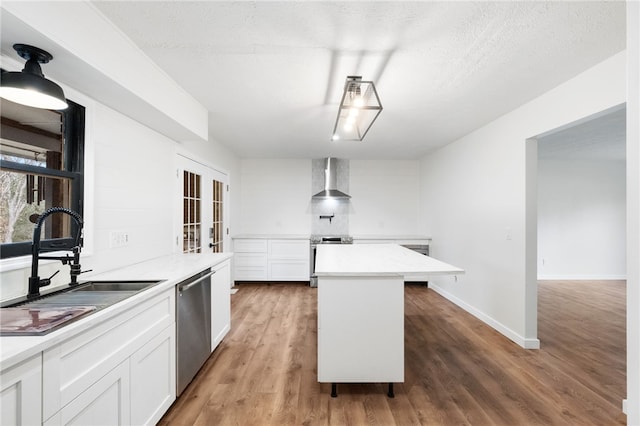 kitchen featuring sink, white cabinetry, wood-type flooring, a center island, and stainless steel dishwasher