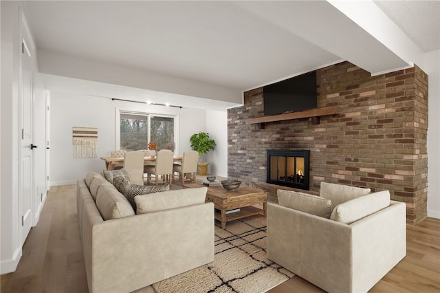 living room featuring a brick fireplace and light wood-type flooring