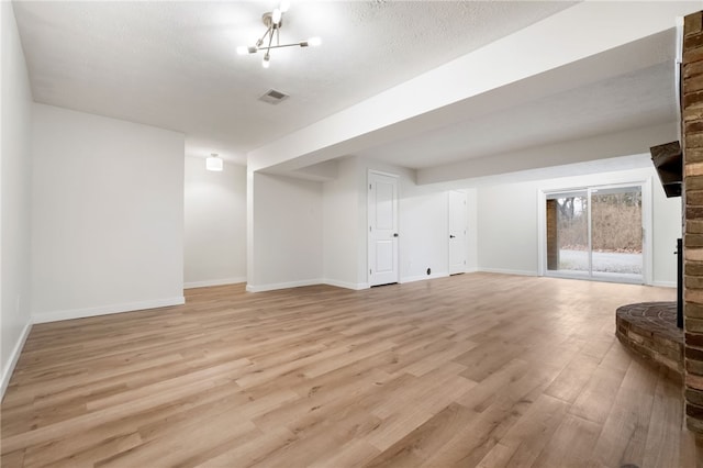 basement featuring a textured ceiling and light wood-type flooring