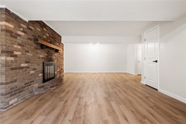 unfurnished living room with light hardwood / wood-style floors and a brick fireplace