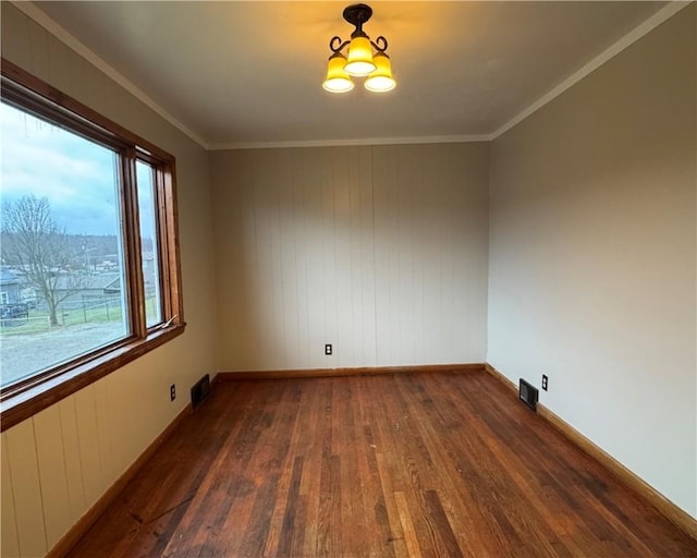 unfurnished room with crown molding, dark wood-type flooring, and an inviting chandelier