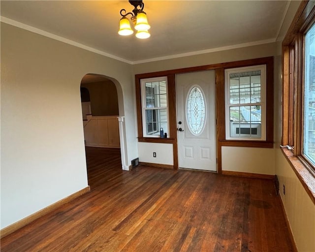 foyer entrance featuring ornamental molding, dark hardwood / wood-style floors, and a chandelier