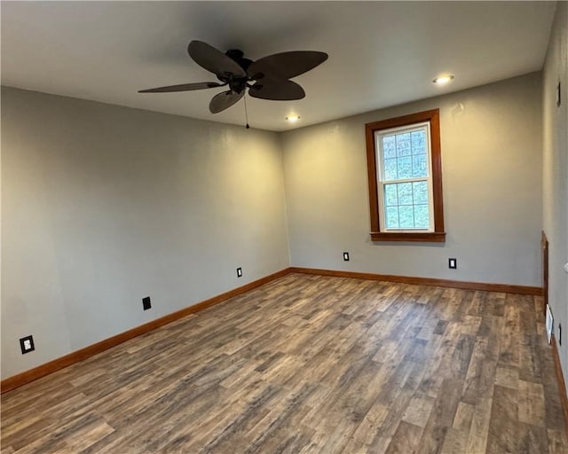 empty room with ceiling fan and dark hardwood / wood-style flooring