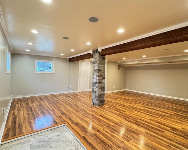 basement with ornamental molding and hardwood / wood-style floors