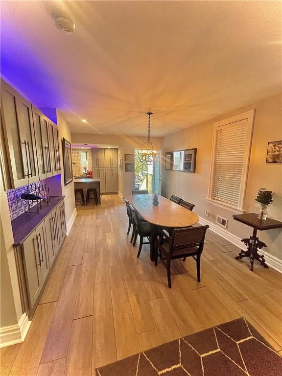 dining room with a notable chandelier and light wood-type flooring