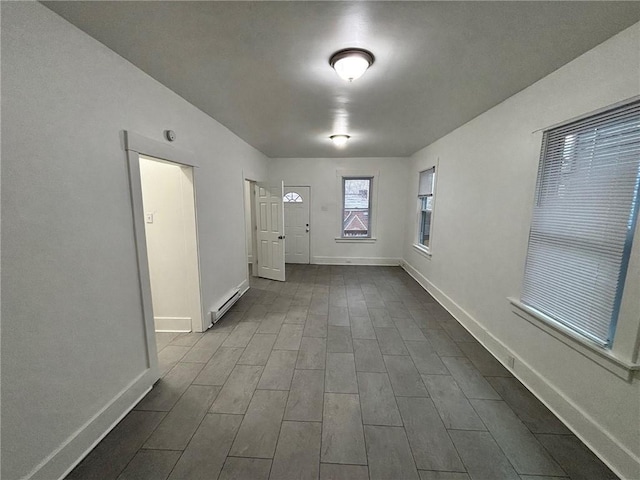 hallway with baseboard heating and wood-type flooring