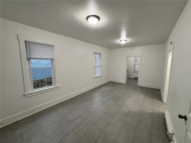 spare room with hardwood / wood-style flooring and a baseboard heating unit