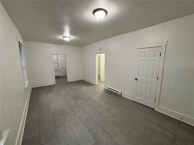 empty room featuring a baseboard radiator and dark hardwood / wood-style flooring