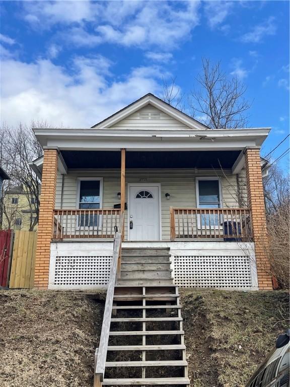 bungalow-style home featuring covered porch and stairway